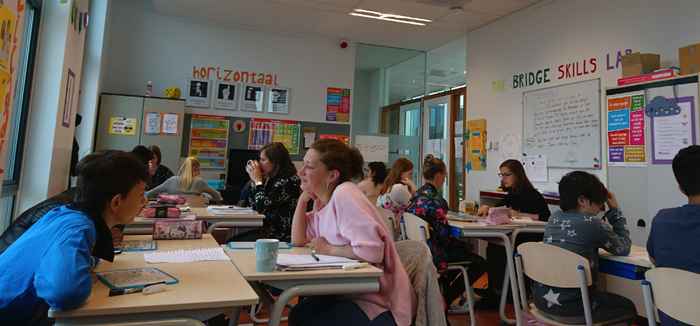 Foto van tutors en kinderen in de klas